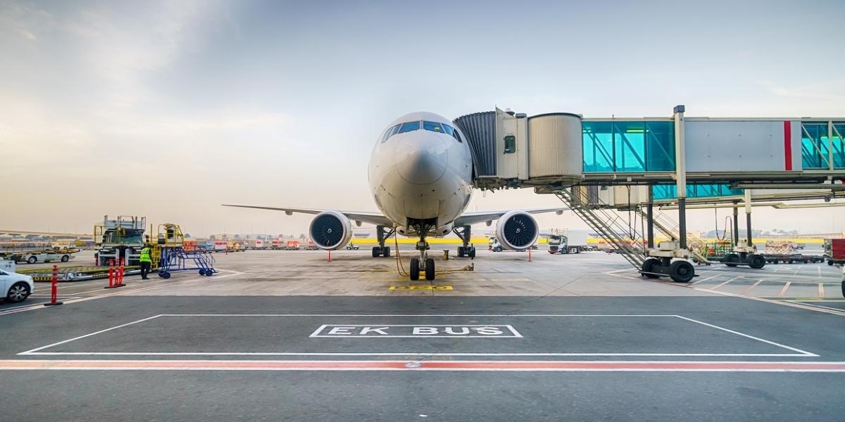 An airplane standing inside an airport with ground workers using grouptalk talk group