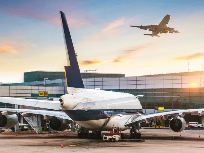 Workers at an airport wearing earmuffs with Push to Talk