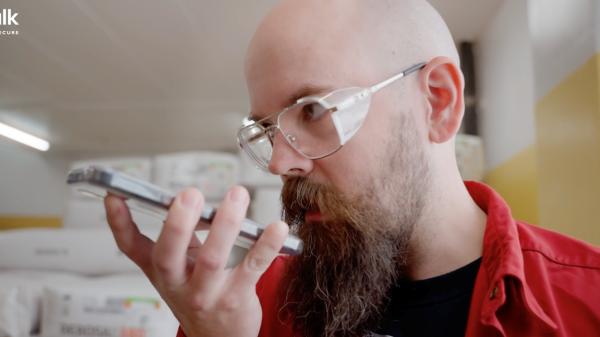 pharmaceutical worker using push to talk app on smartphone for internal communication