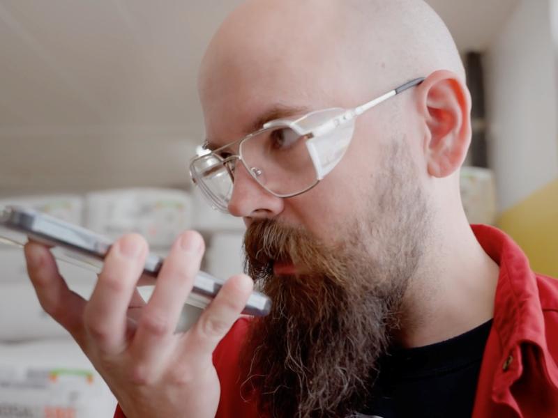 pharmaceutical worker using push to talk app on smartphone for internal communication