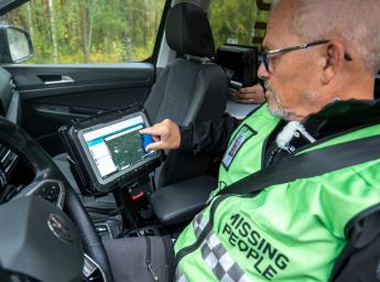 Volunteer for missing people sitting in a car and monitoring the searching team through a iPad.