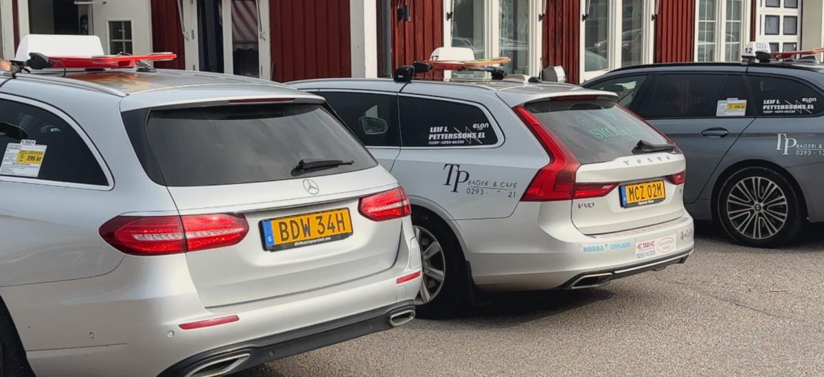 Three taxi cars is parked beside each other.