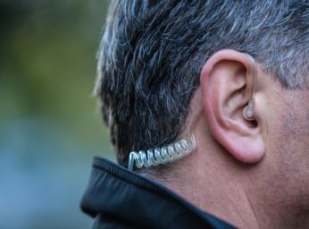 Security guard using listen only headset usb-c for push to talk communication.