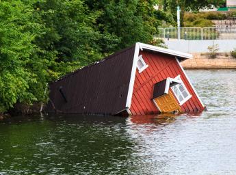 Flooded house surrounded by water.