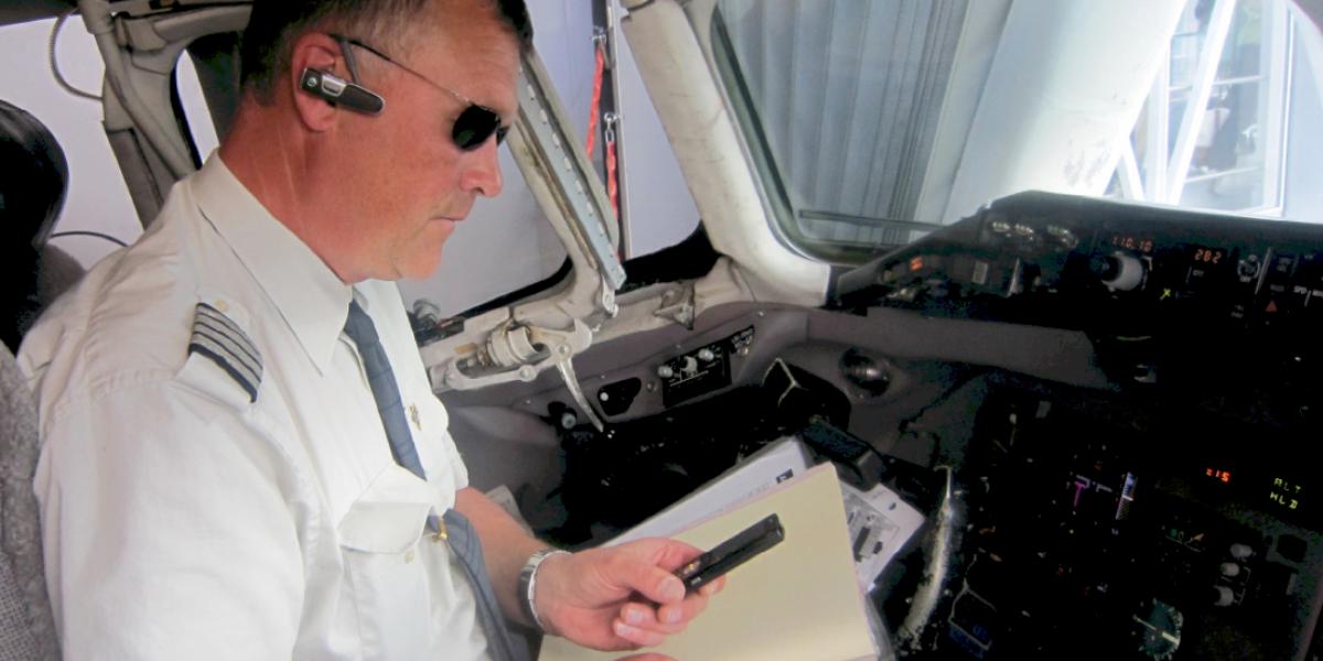 Pilot with bluetooth headset and speaks through Push to Talk to his colleagues.